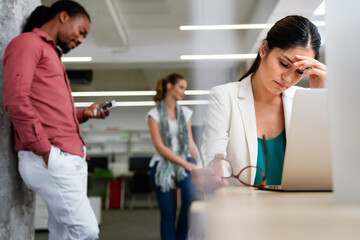 Fototapeta premium Young woman at office desk working on laptop with stress, neck pain and exhaustion.