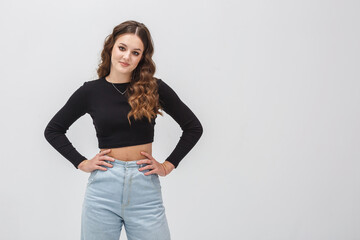 girl model in white shirt and black trousers sits relaxed in studio