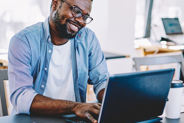 Man smiling while working on laptop