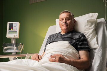 Senior in hospital bed, oxygen tube, finger monitor, shows signs of tiredness and fatigue,...