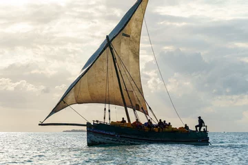 Zelfklevend Fotobehang dramatic skyline with the dhow a traditional sailing vesssels of zanzibar tanzania © mikefoto58