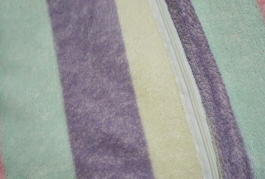 a close up of the purple and yellow striped blanket.