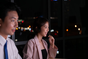Group of broker international stock traders wearing headset working actively at night in office, Concept of customer support agent provide service on telephone.
