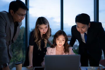 Group of broker international stock traders working actively at night in office, A young woman is...