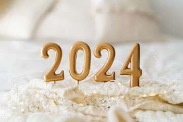 Happy New Years 2024. Christmas background with 2024 candles and white knit sweater. Christmas holiday celebration. New Year concept.