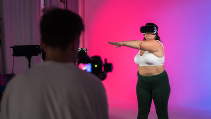 Photographer taking portraits of an overweight woman with VR headset