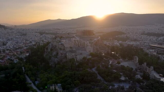 Aerial view of the skyline and ancient ruins at the Acropolis of Athens, Greece, with Parthenon Temple and Odeon of Herode theatre during a golden sunrise