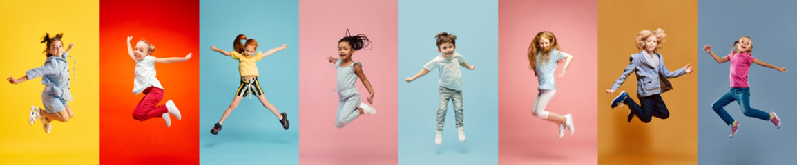 Collage. Happy, adorable little boys and girls, children cheerfully lumping over multicolored background. Concept of freedom, motivation, ambitions, success and lifestyle, childhood