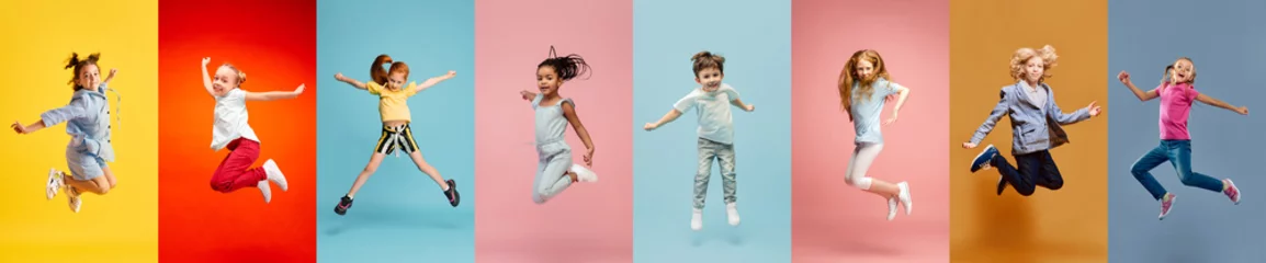 Fotobehang Collage. Happy, adorable little boys and girls, children cheerfully lumping over multicolored background. Concept of freedom, motivation, ambitions, success and lifestyle, childhood © master1305