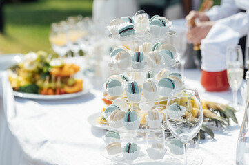 Colorful macaroons on candy bar. Sweet macarons at outdoor buffet. Top view