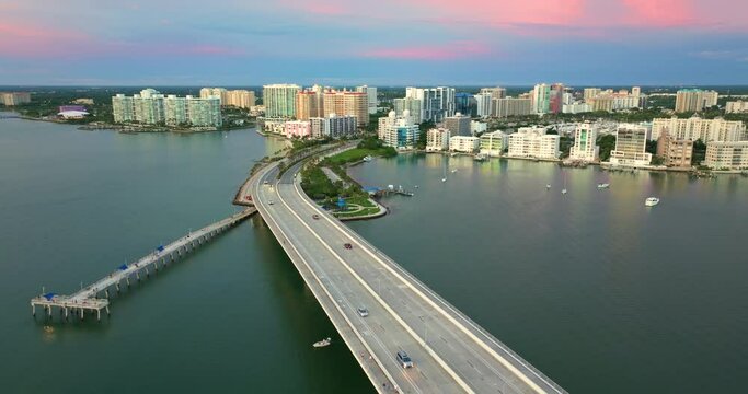 USA travel destination. Evening aerial view of Sarasota city downtown with Ringling Bridge and high-rise office buildings on horizon. Real estate development in Florida