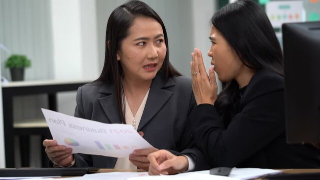group of asian office worker woman talking or whispering gossip with colleague rumors to coworker in office