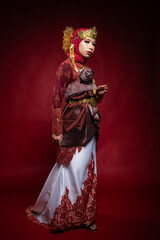 An Asian female traditional damcer wearing a traditional apparel and accessories dancing the traditional dance