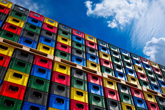 Countless colorful beer crates full of bottles stacked in an outdoor warehouse.