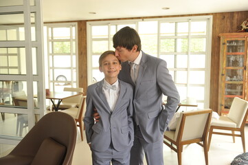 pai e filho juntos usando terno elegânte em preparação para casamento 