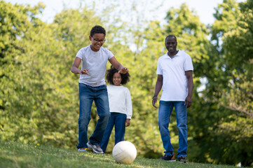 Naklejka premium Family playing football in the park