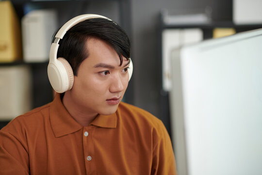 Portrait of developer reviewing programming code on computer screen