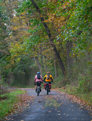 Two touring bicyclists riding together along an Autumn rural road