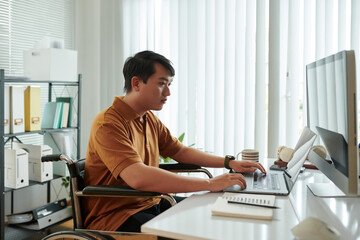 Serious young businessman working on computer in his home office