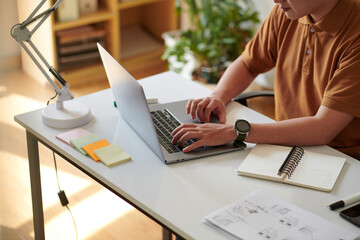 Cropped image of software developer working on project at desk in home office