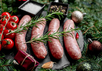 Christmas raw sausages on a background of fir trees and Christmas decorations