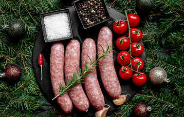 Christmas raw sausages on a background of fir trees and Christmas decorations