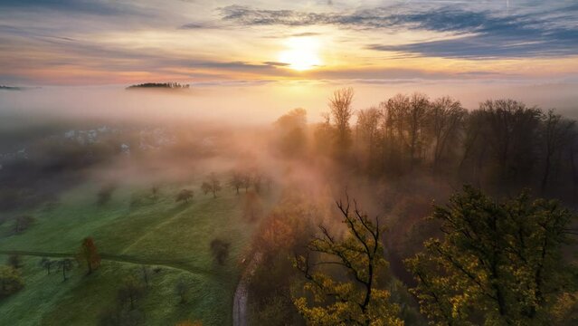 Hyperlapse time lapse footage of amazing scenic rural landscape with the fog gliding over the meadows and trees towards the rising sun

