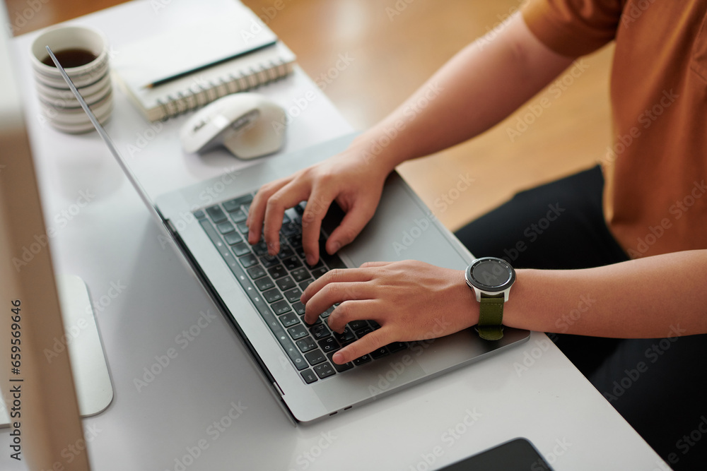Wall mural hands of devops engineer working on laptop at home