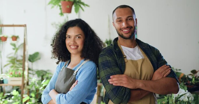 Portrait of African American joyful couple happy man and woman in aprons standing at own small flower shop and looking smiling to camera. Family business concept.