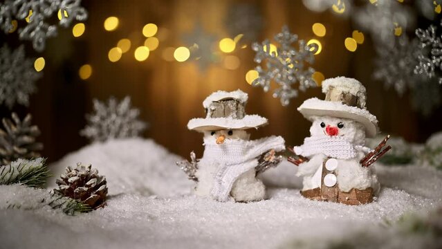 Cute snowman figures with decorated festive background, lights and ornamental hanging snowflakes. Footage for Christmas, New Year or winter
