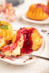 Semolina cheesecake with strawberry jam on gray concrete, side view, selective focus.