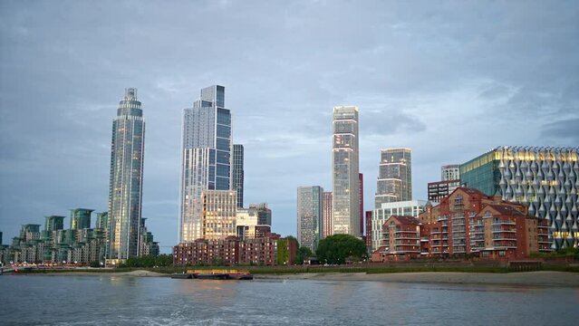 View of London from a floating boat on the Thames River at sunset, United Kingdom. Skyscrapers and modern buildings located along the river