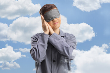 Young man in pajamas wearing a sleeping mask