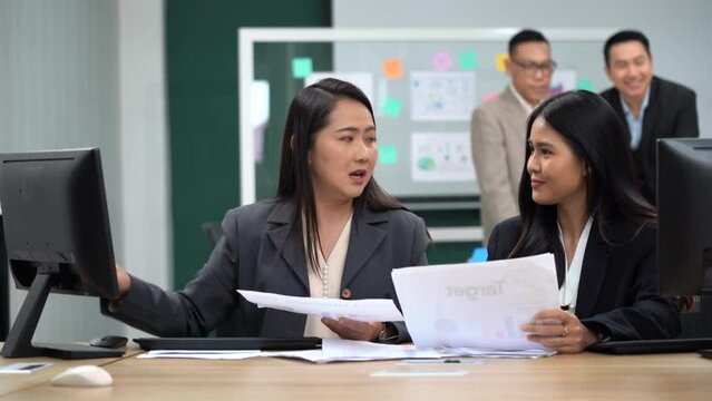 group of asian office worker woman talking and working with paper work and computer in office with colleague