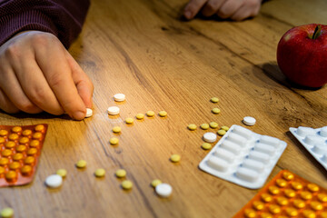 hand making sad face  out of pills on the table drugs addiction concept 