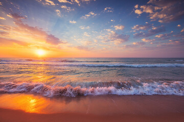 Fototapeta na wymiar Beautiful cloudscape over ocean waves and tropical beach, sea horizon at sunrise