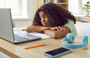 Student gets bored during online lesson. Elementary school child thinking about something else...