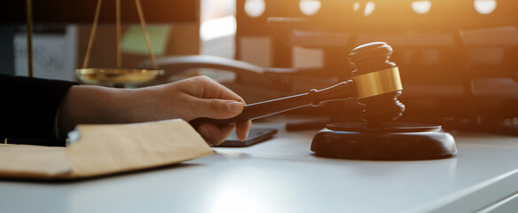 Judge gavel with Justice lawyers having team meeting at law firm in background. Concepts of law.