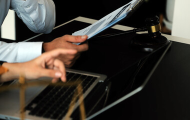 Judge gavel with Justice lawyers having team meeting at law firm in background. Concepts of law.