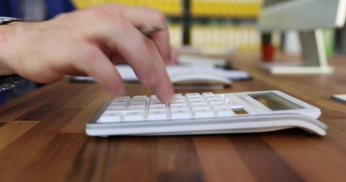 Businessman accountant counting on calculator and writing down data on paper closeup 4k movie. Accounting and auditing in business concept