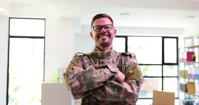 Military man in glasses folding hands in front of camera and smiling in office 4k movie slow motion. Military career concept