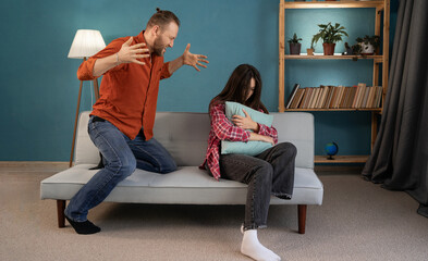 Young couple having argument in the living room. Conflict, bad relationships in the family. Angry...