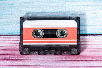 Obraz premium Top view of a music cassette on a background of colored wood.