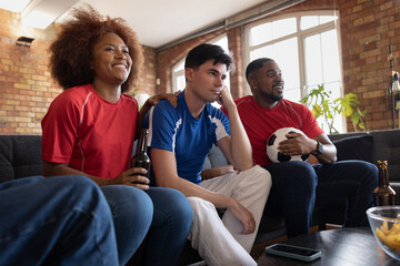 Friends watching a football match at home