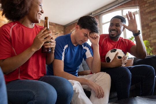 Friends watching a football match at home