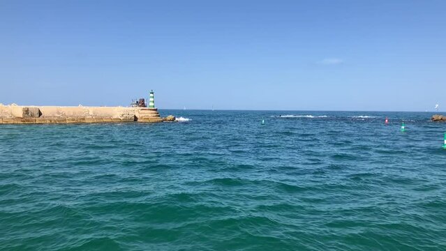 Lighthouse of Ancient Jaffa. Andromeda stones and the flag of Israel.