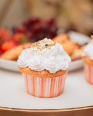 Plano frontal de cupcake con cubierta de crema blanca y perlas con fondo de frutas 