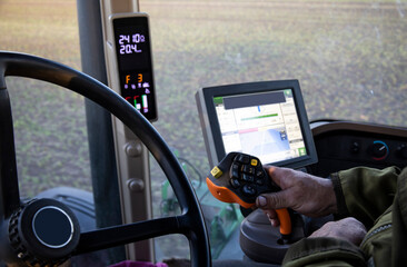 The operator of the special tractor processes agricultural fields. Close-up of the tractor driver's workplace.