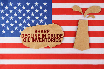 On the US flag, an oil rig figure and a sign with the inscription - a sharp reduction in crude oil reserves.