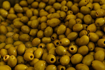 Seasoned olives in a container with marinate on the counter.